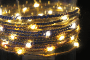 eine leuchtende Lichterkette mit Micro LEDs, die spiralartig mit einem Faden umsponnen sind