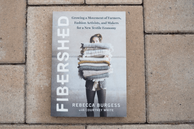 Buch "Fibershed" liegt auf Terrassenfliesen