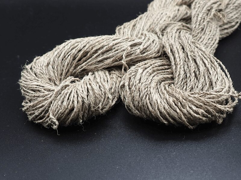 Nahaufnahme zwei Stränge Leinengarn aus Fasern geerntet nach 100d (links) und 115d (rechts). Hintergrund schwarz