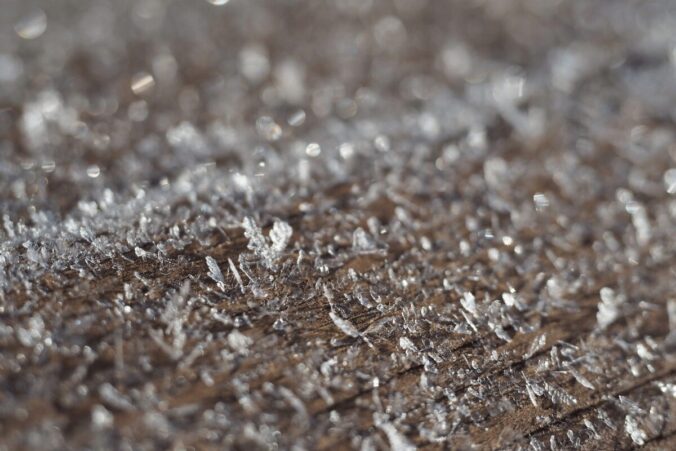 Nahaufnahme von Eiskristallen auf Holz